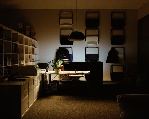 A modern living room space in Guadalajara with warm artificial lamps illuminating a study desk area